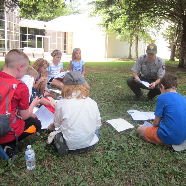 A park ranger works with students