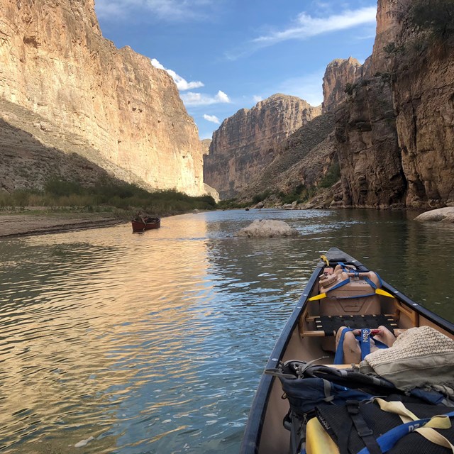 Two canoes navigating the Rio Grande River channel.