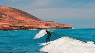 Surfer along coastline. ©Tim Hauf, timhaufphotography.com