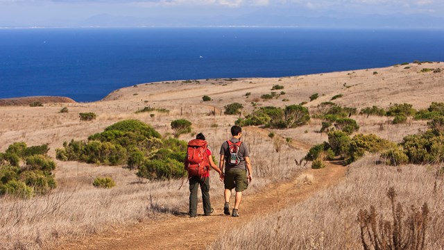 Visitors hiking on trail with view of ocean. ©Tim Hauf, timhaufphotography.com