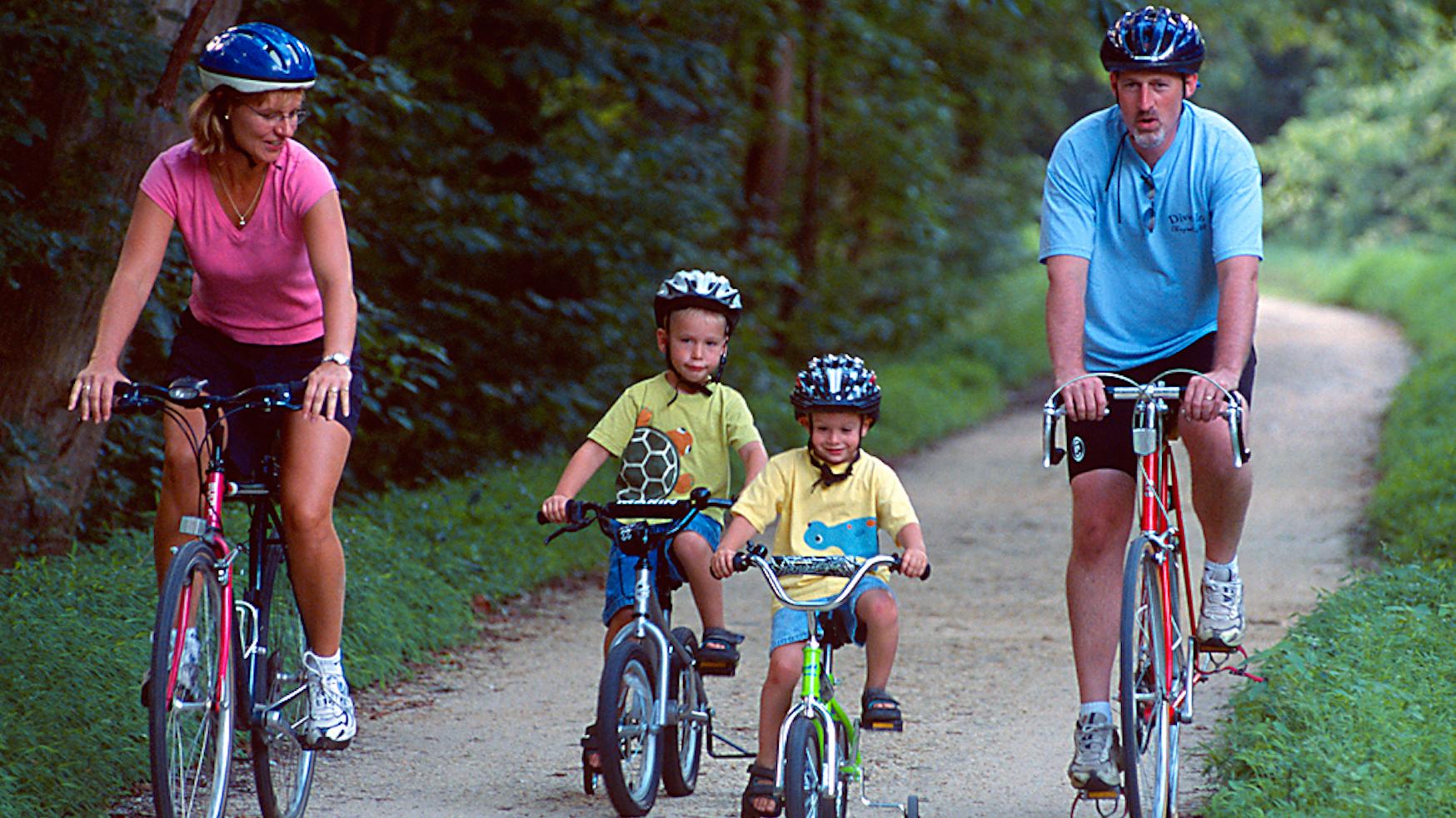 Two adults and two children biking on the Canal towpath.