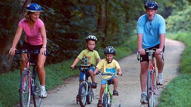 Two adults and two children biking on the Canal towpath.