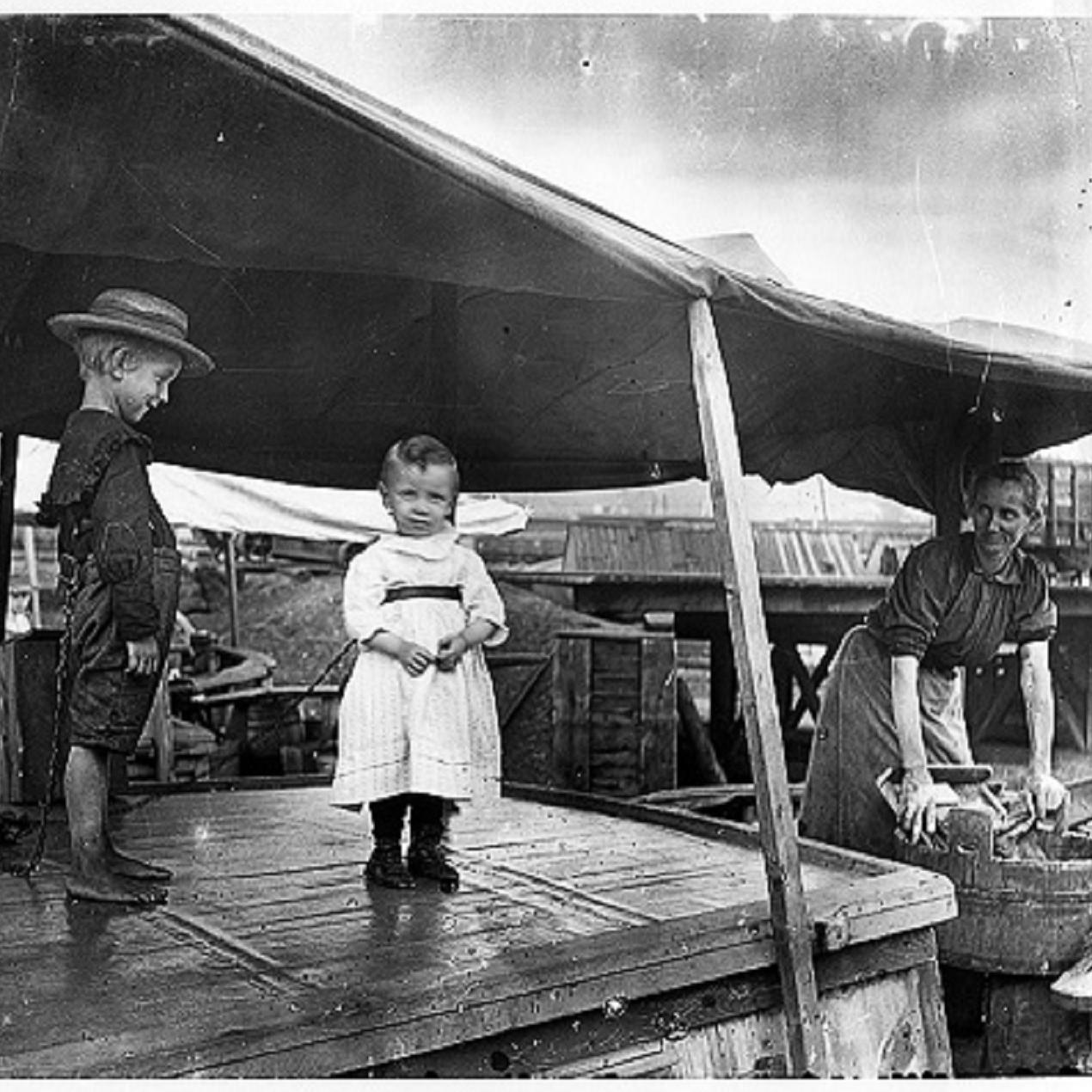 Two small children tied to the cabin of a canal boat as a precaution.