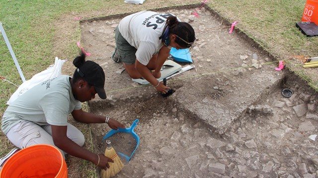 Photo of archeologist and student intern excavating remains of historic building at Christiansted.