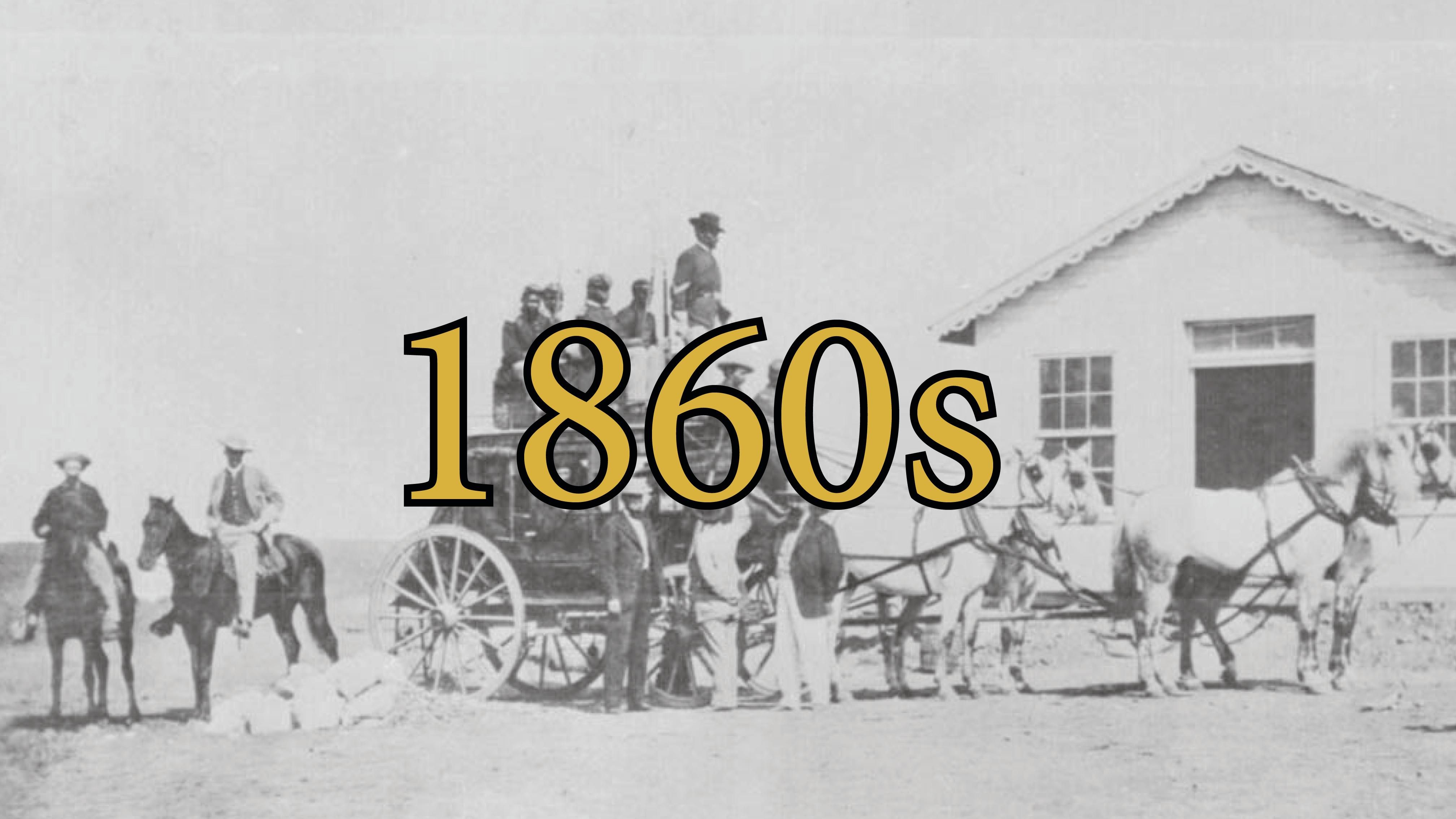 Black and white photo of numerous people standing in and on a stage coach.