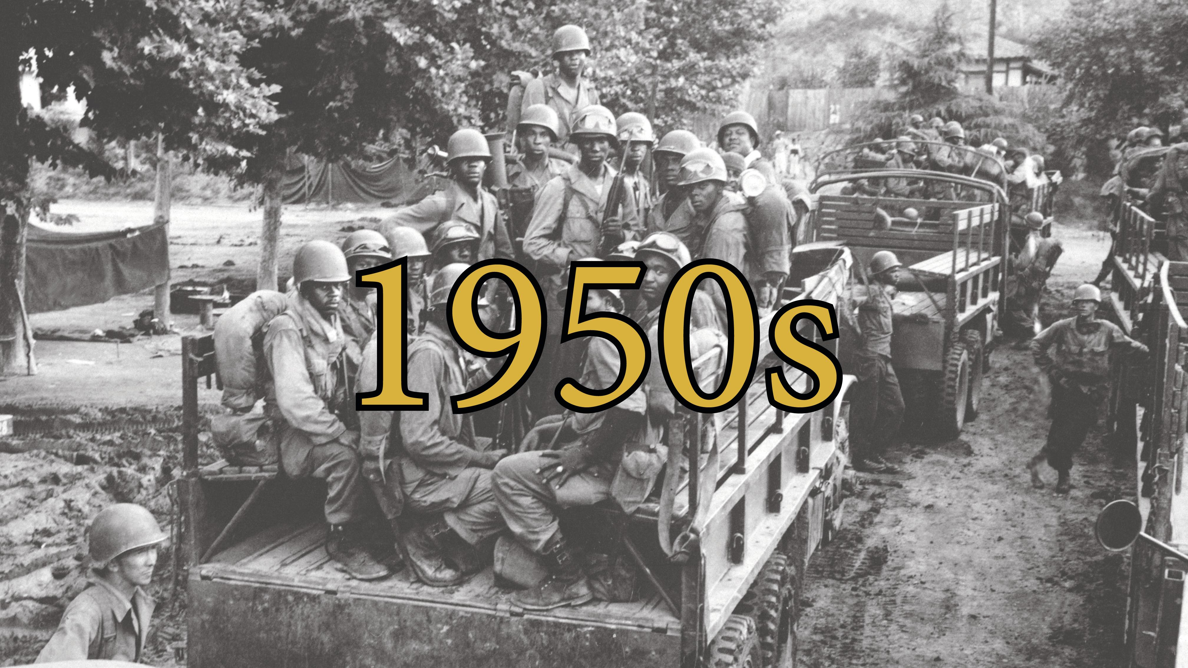 Black and white photo of a group of African American soldiers with combat gear on the back of truck