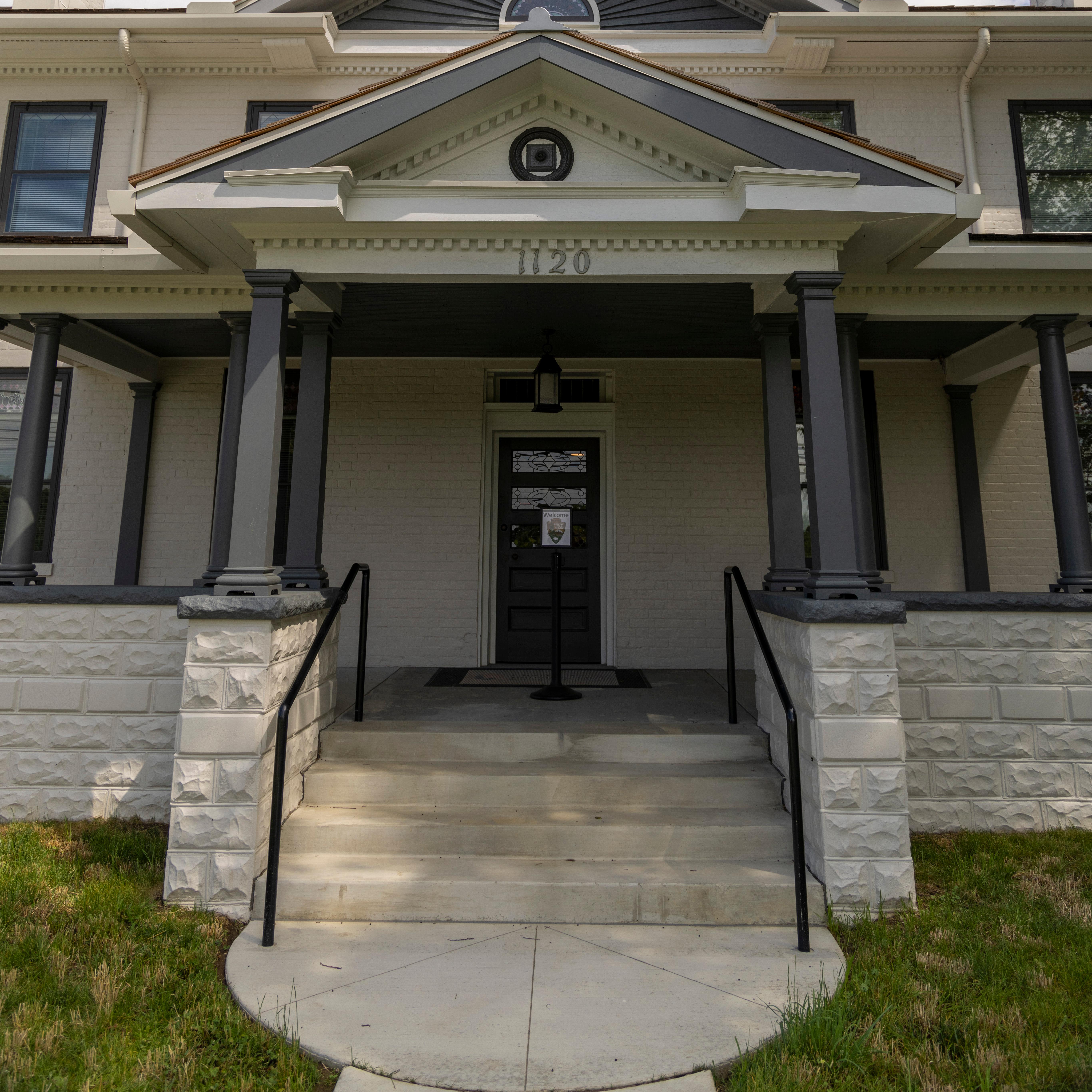 A large two-story house with two peaked roofs, one on the first floor and the other on the top level
