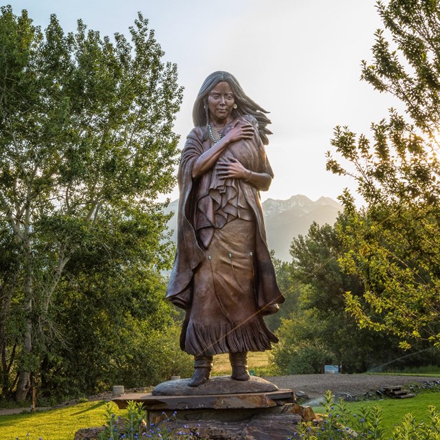 A statue of a woman, Sacagawea, holding a baby