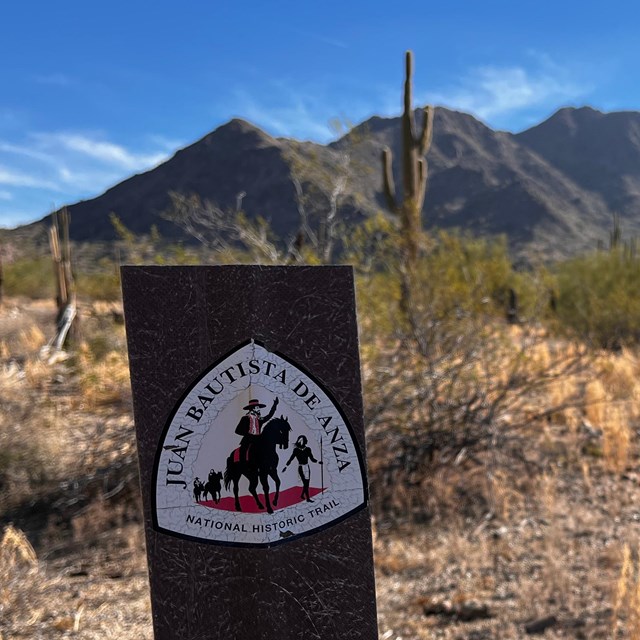 A desert background with Anza trail signage in the foreground