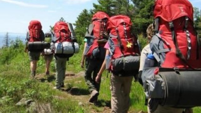 people backpacking on a trail