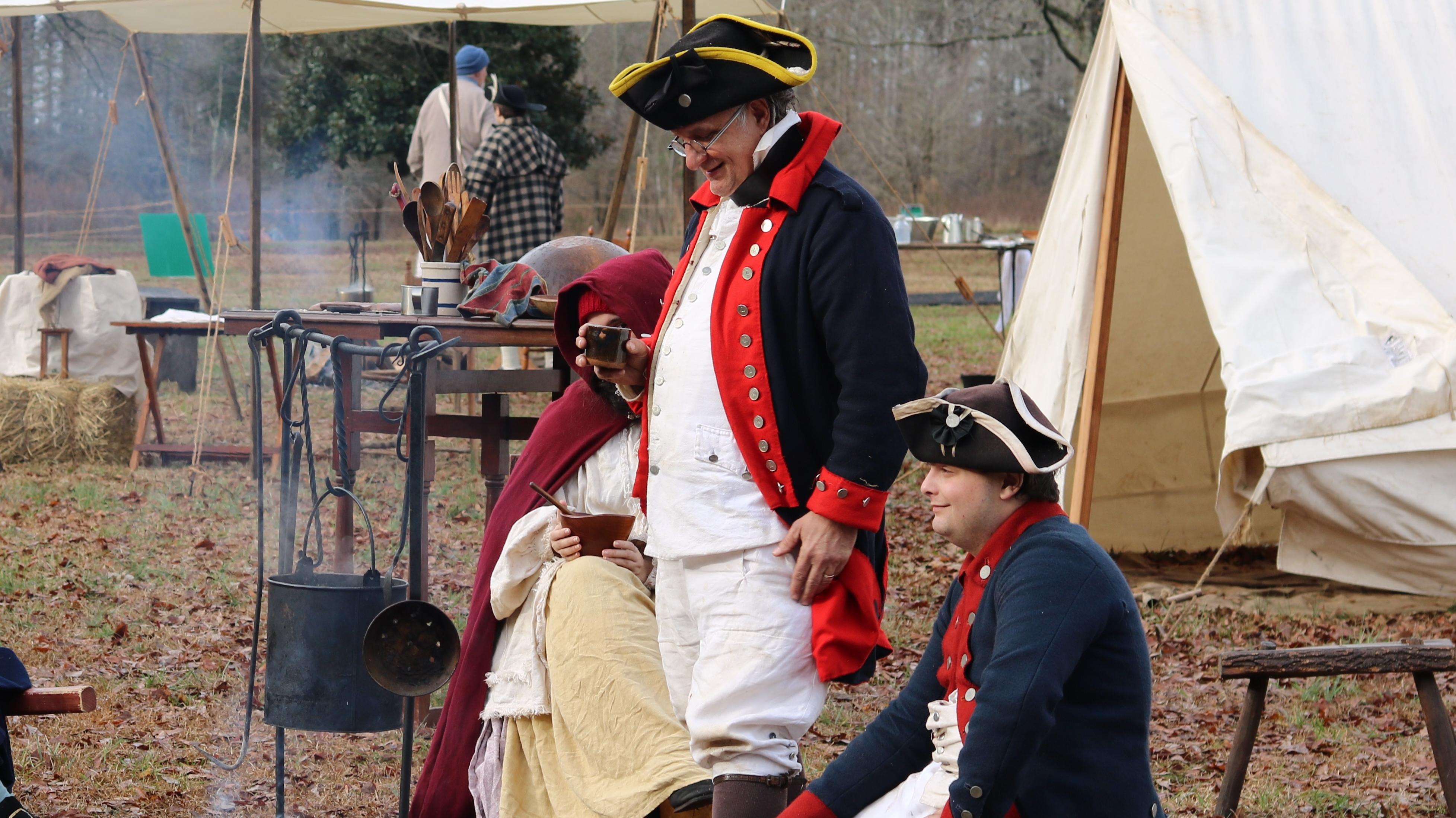 Image of reenactors talking around a fire