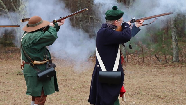 Reenactors firing muskets