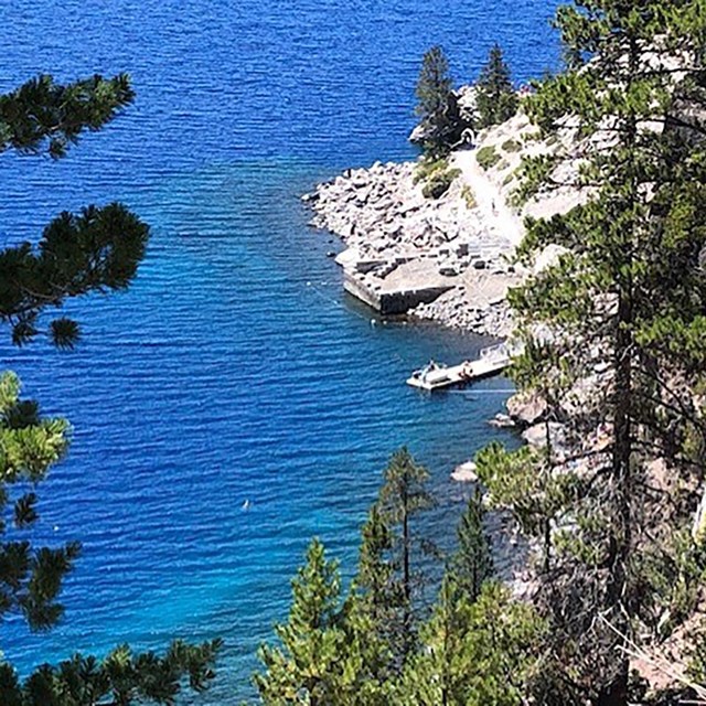 An treetop view of the Cleetwood Cove section of Crater Lake with boat dock trail.