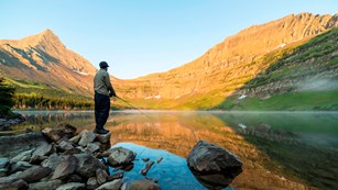 Man standing by a lake fishing