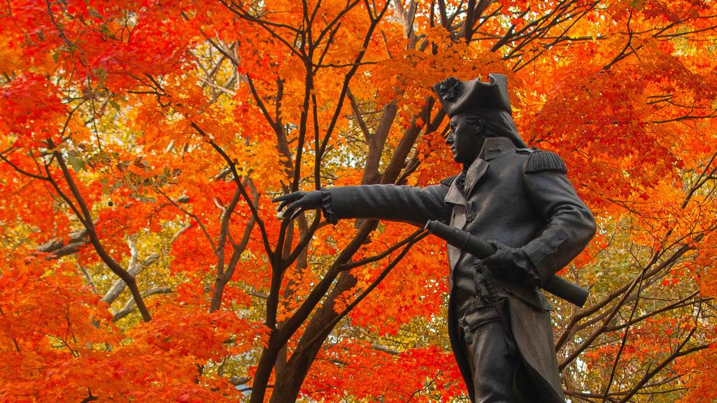 Statue of John Barry surrounded by bright red fall foliage