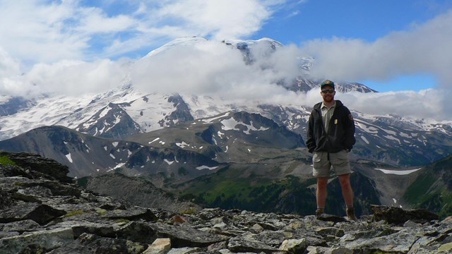 Hiker heading towards a large mountain 