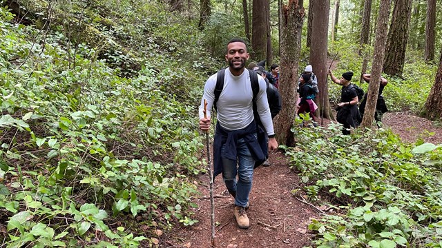 Hiker walking up a hill in a forest 