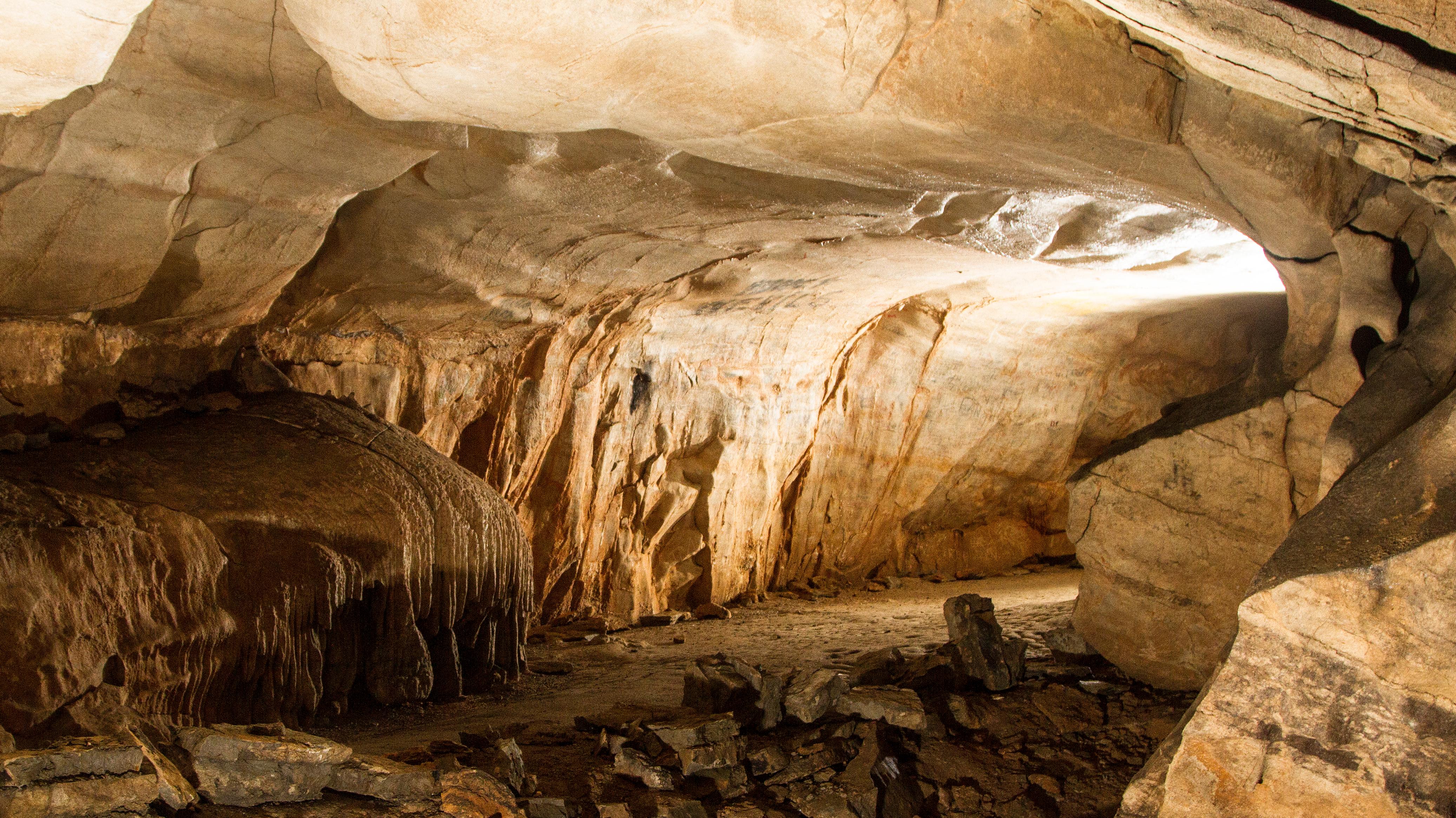 A cave passage with light shining through. 