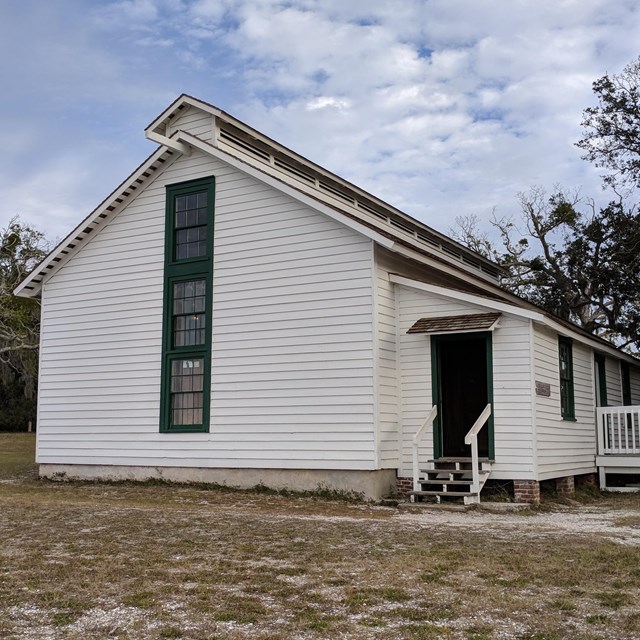 White building with large vent system in roof, on sandy soils