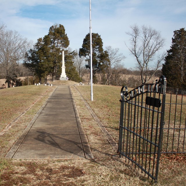 View through gates towards obelisk monument in Groveton Cemetery