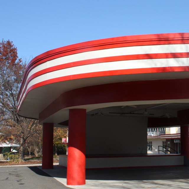The red and white striped awning curves around the Cuddle Up Pavilion 