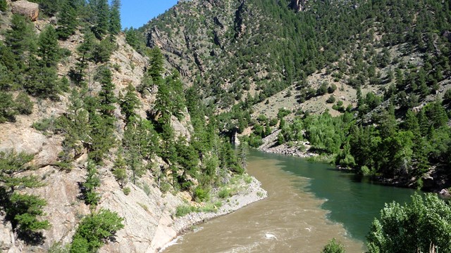 A photo of the confluence of two rivers in between canyon walls