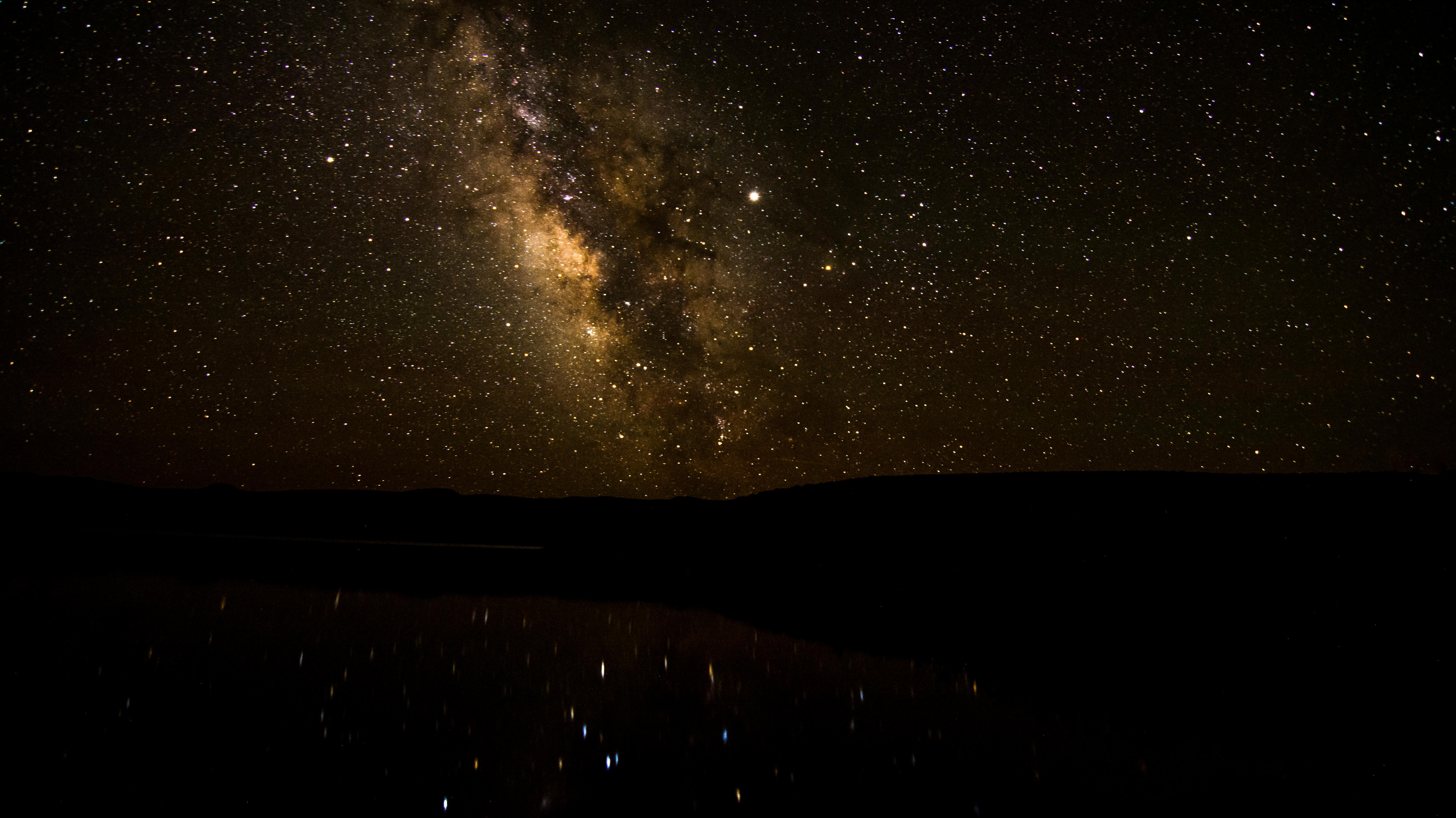 Image of the Milky Way and stars reflected over a body of water