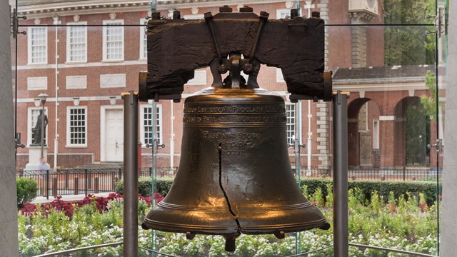 An image of the liberty bell, its crack prominently shown in the front. 