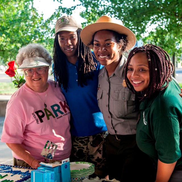 A group smiles for a photo with a ranger.