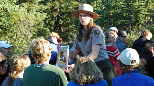 a ranger standing amid a seated crowd at an outdoor amphitheater