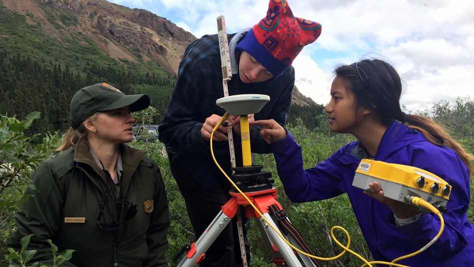 campers work with a ranger to set a survey station 