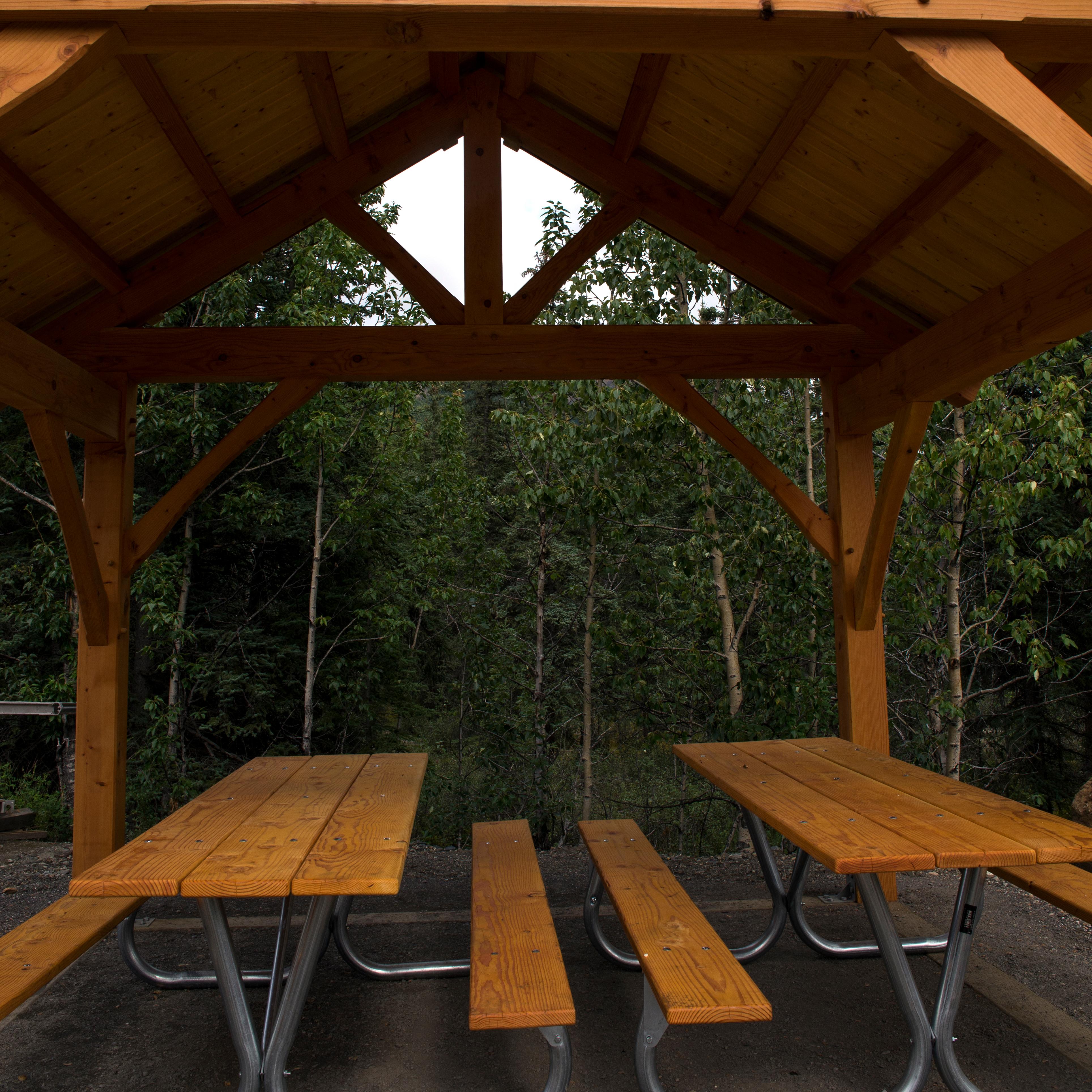 picnic tables under a large wooden structure