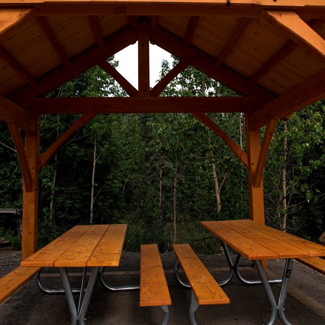 picnic tables under a large wooden structure