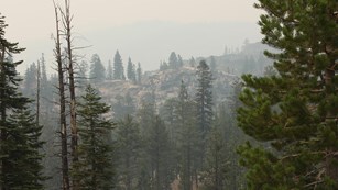 Smoke obscures the mountain ranges across the valley.