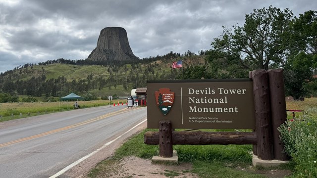 The welcome sign and entrance station in front of the Devils Tower monolith 
