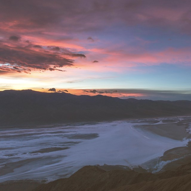 A sunset from Dantes View. Most of the landscape is shadowed by the deep blue of darkening twilight.