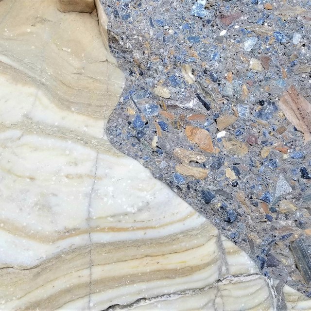 A closeup of a smooth canyon wall where marble abruptly transitions to a conglomerate of naturally.