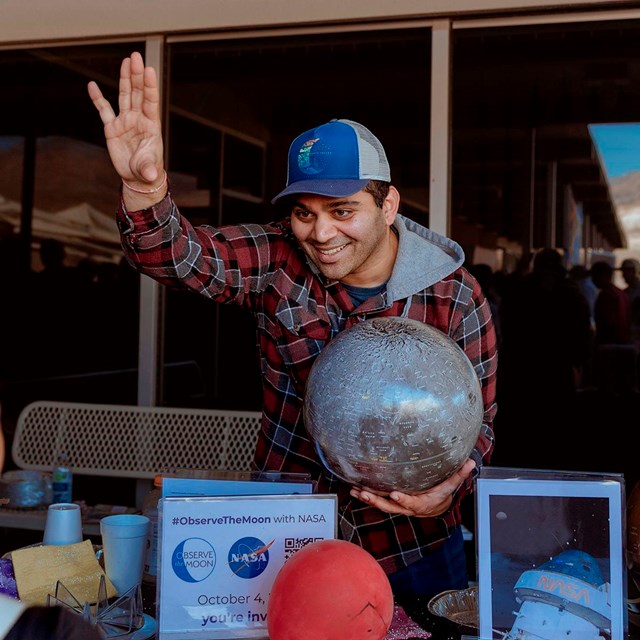 A lively scene at an event where an enthusiastic presenter engages with an audience.