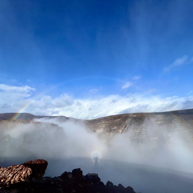 Rainbow Canyon filled with fog and a rainbow in the middle. NPS/E.Forster