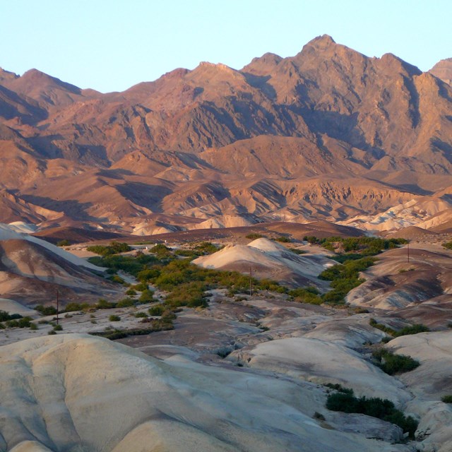 The photograph features an expansive desert landscape characterized by rolling, multicolored hills.