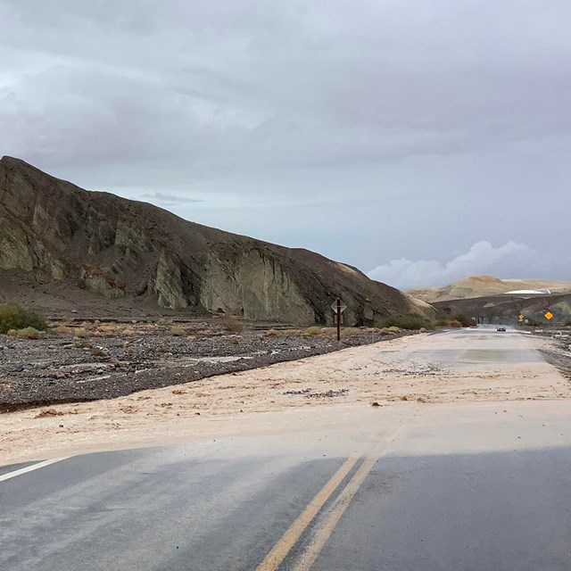 The distant mountains, streaked with muted browns and yellows, rise sharply against sky.