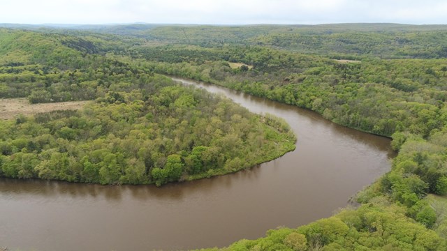 A view of the Walpack bend part of the river surrounded by green trees.