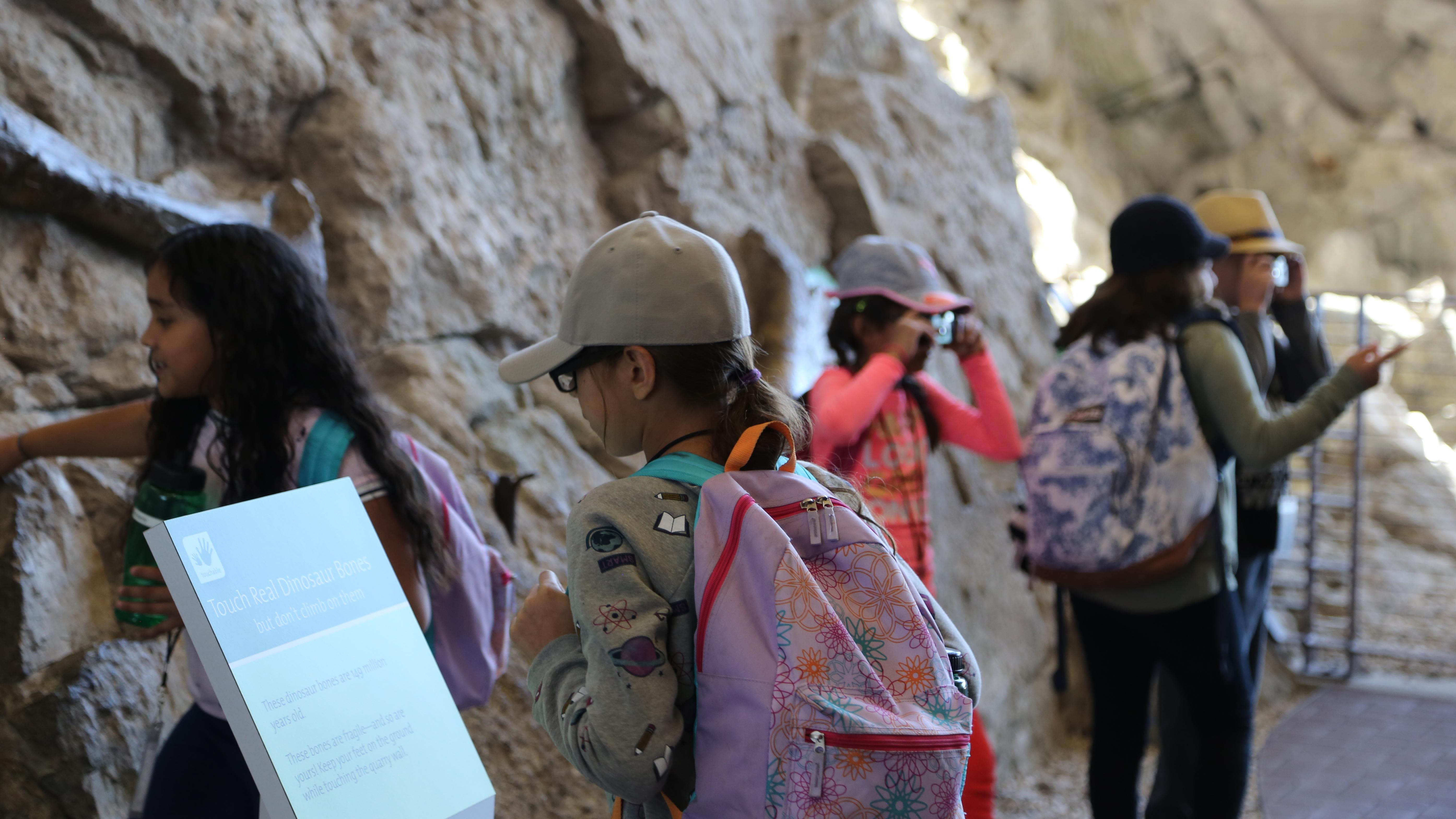 Kids explore the fossil wall at the Quarry Exhibit Hall.