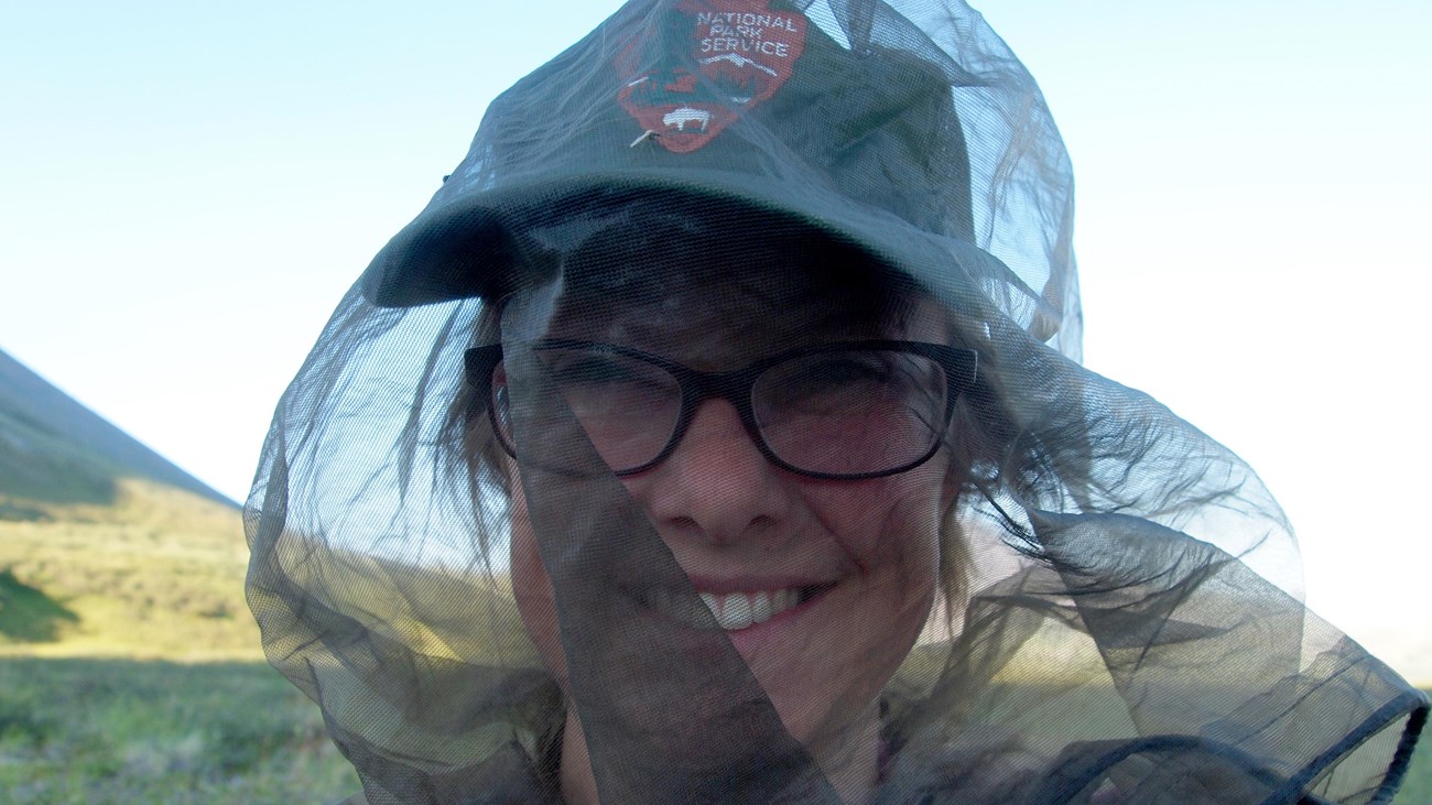 Woman in National Park Service hat covered with mosquito net