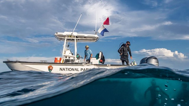 NPS boat with scientist diving in the blue water.