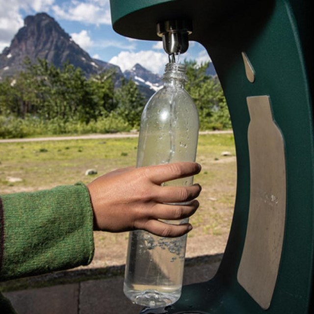 a water bottle filling station is used to refill a water bottle