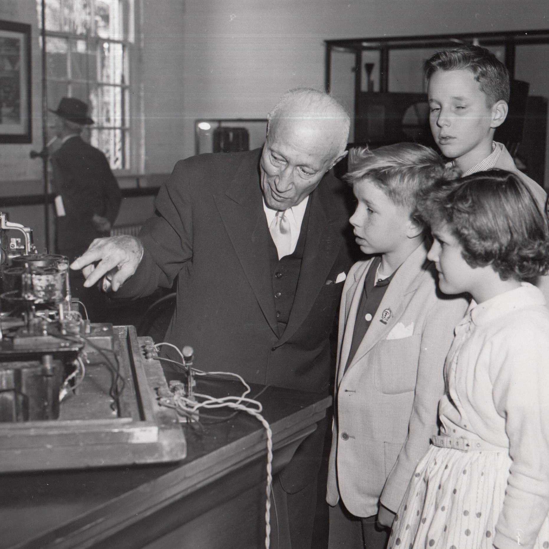 Zukor of Paramount shows a kinetograph to interested children (historic photo, black and white)