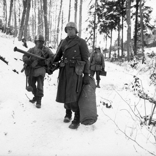 A black and white image of soldiers marching in snow