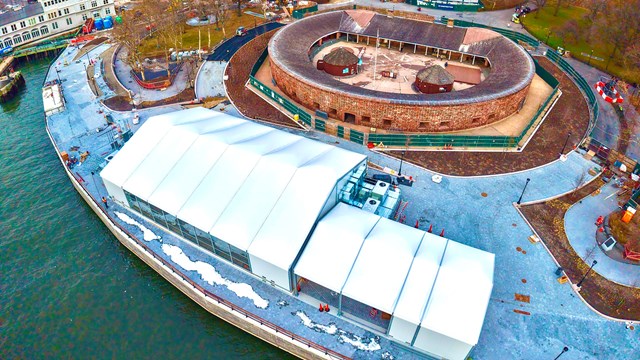 An aerial view of the white security building next to an oval structure.