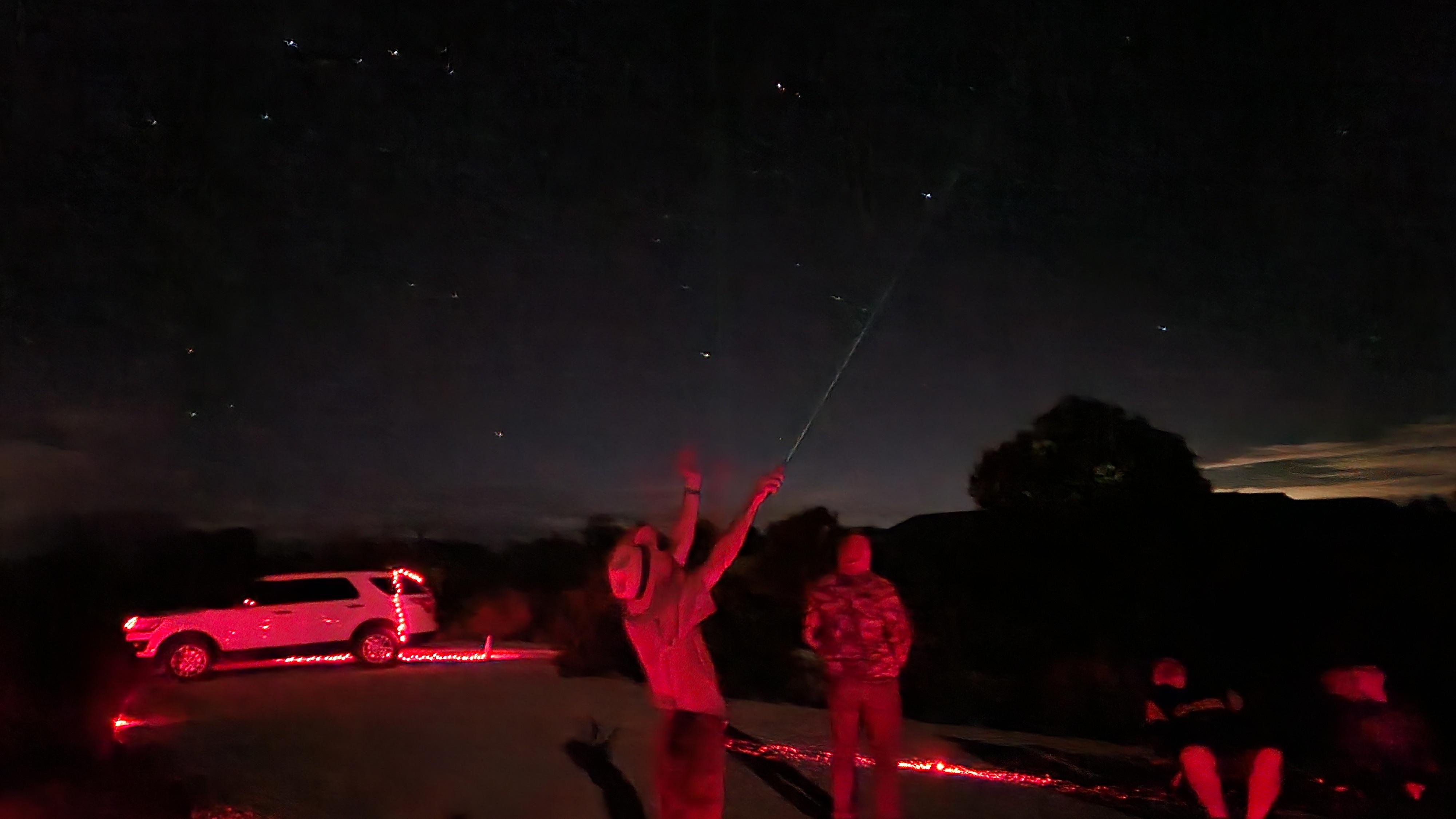 A ranger points to the sky during an astronomy program. 